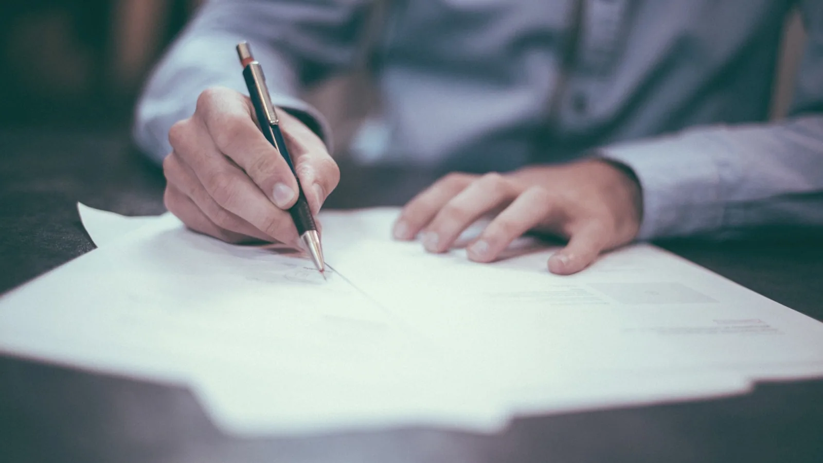 Pluma firmando una escritura notarial representando el divorcio express