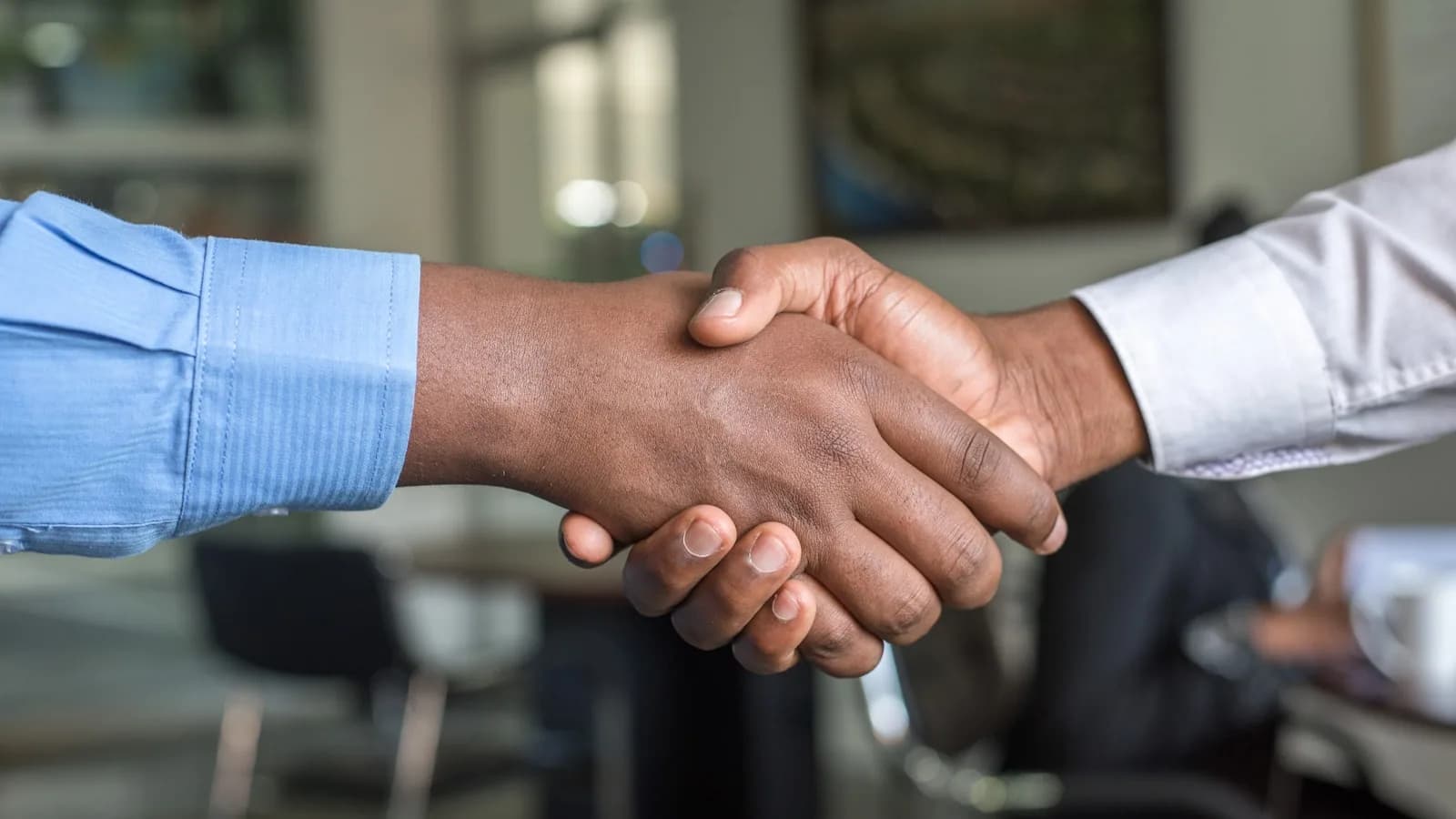 Dos personas y un mediador en mesa de negociación representando la mediación familiar
